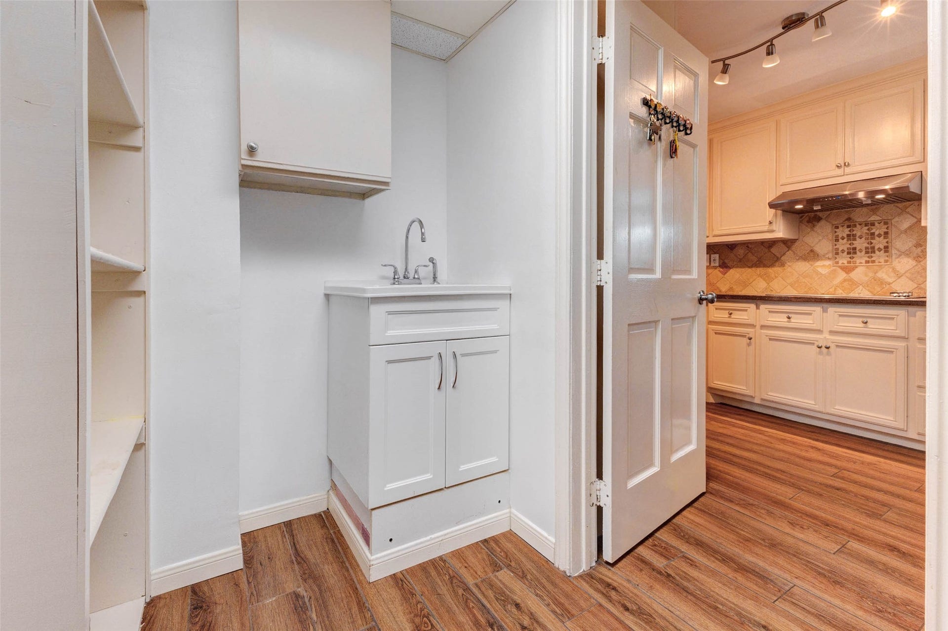 11418 Cedarwood Drive, Humble, TX 77338 A convenient utility or service area sits just off the kitchen, offering a sink, cabinetry, shelving, and additional functional storage. This practical space is ideal for household organization, cleaning supplies, pantry overflow, pet care, or everyday drop-zone needs, with easy access back into the kitchen and main living areas.