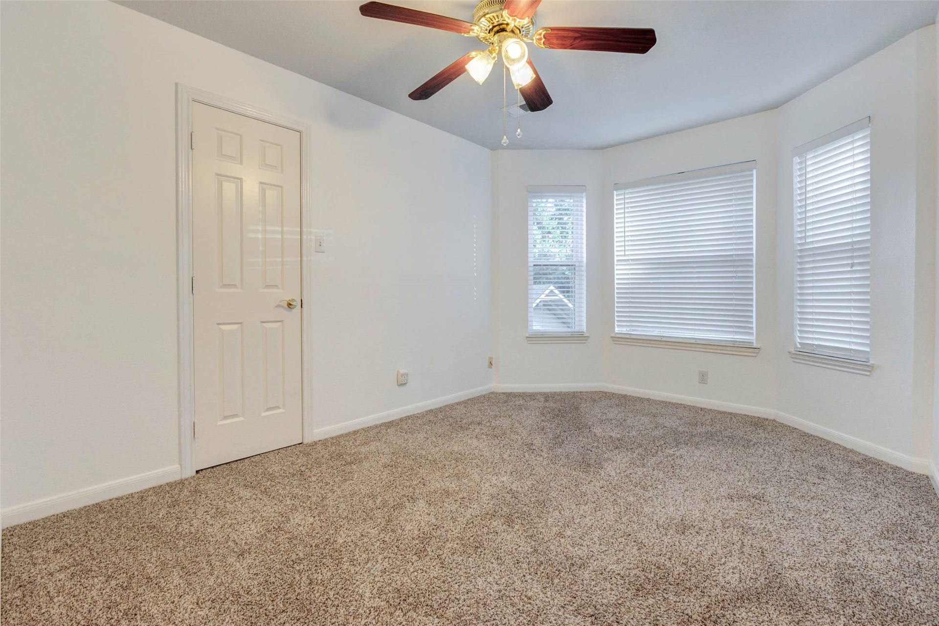 11418 Cedarwood Drive, Humble, TX 77338 This secondary bedroom offers soft carpet, neutral walls, a ceiling fan, closet storage, and multiple windows with blinds that bring in natural light. The comfortable layout provides flexibility for a guest room, childs bedroom, home office, hobby space, or study area, with a clean, neutral backdrop ready for the next owners personal style.