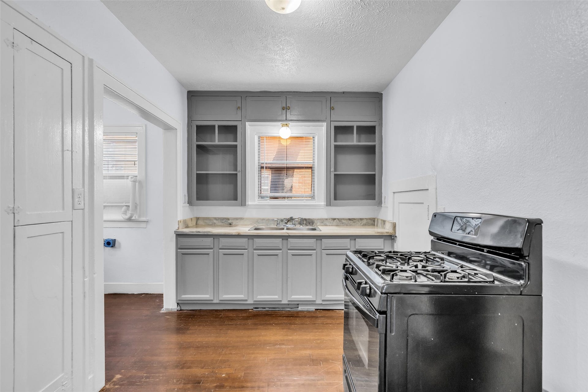 A full view of the kitchen shows its practical layout and a door leading to a small adjoining room, providing added convenience and flexibility.