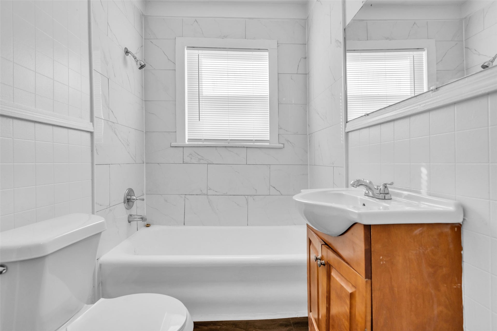 The first-floor bathroom in the duplex features a convenient tub and shower combination, providing a practical setup for everyday use.