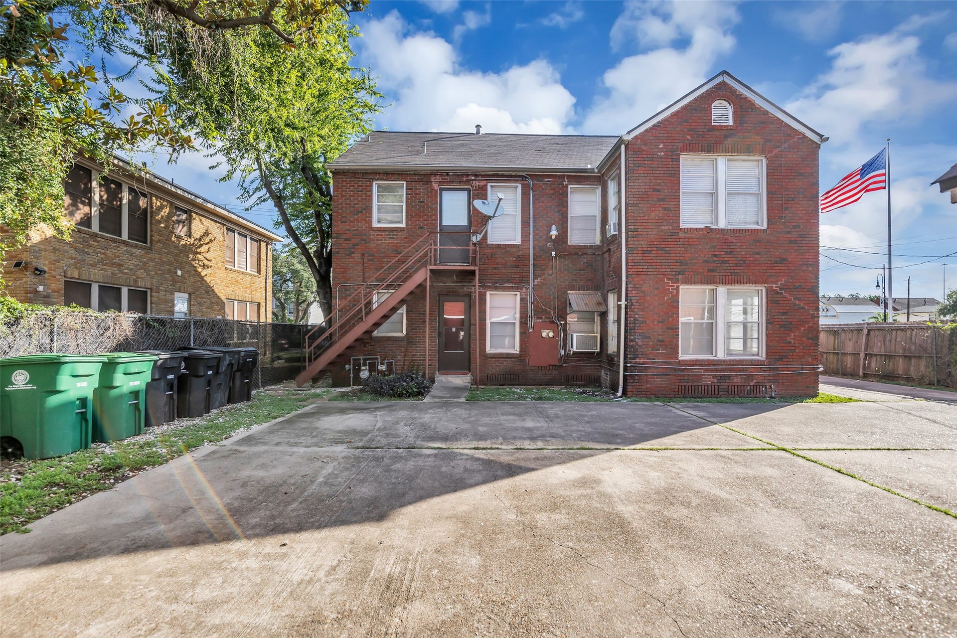 The rear view of the two-story brick duplex highlights its solid brick exterior and additional perspective of the homes structure and layout.