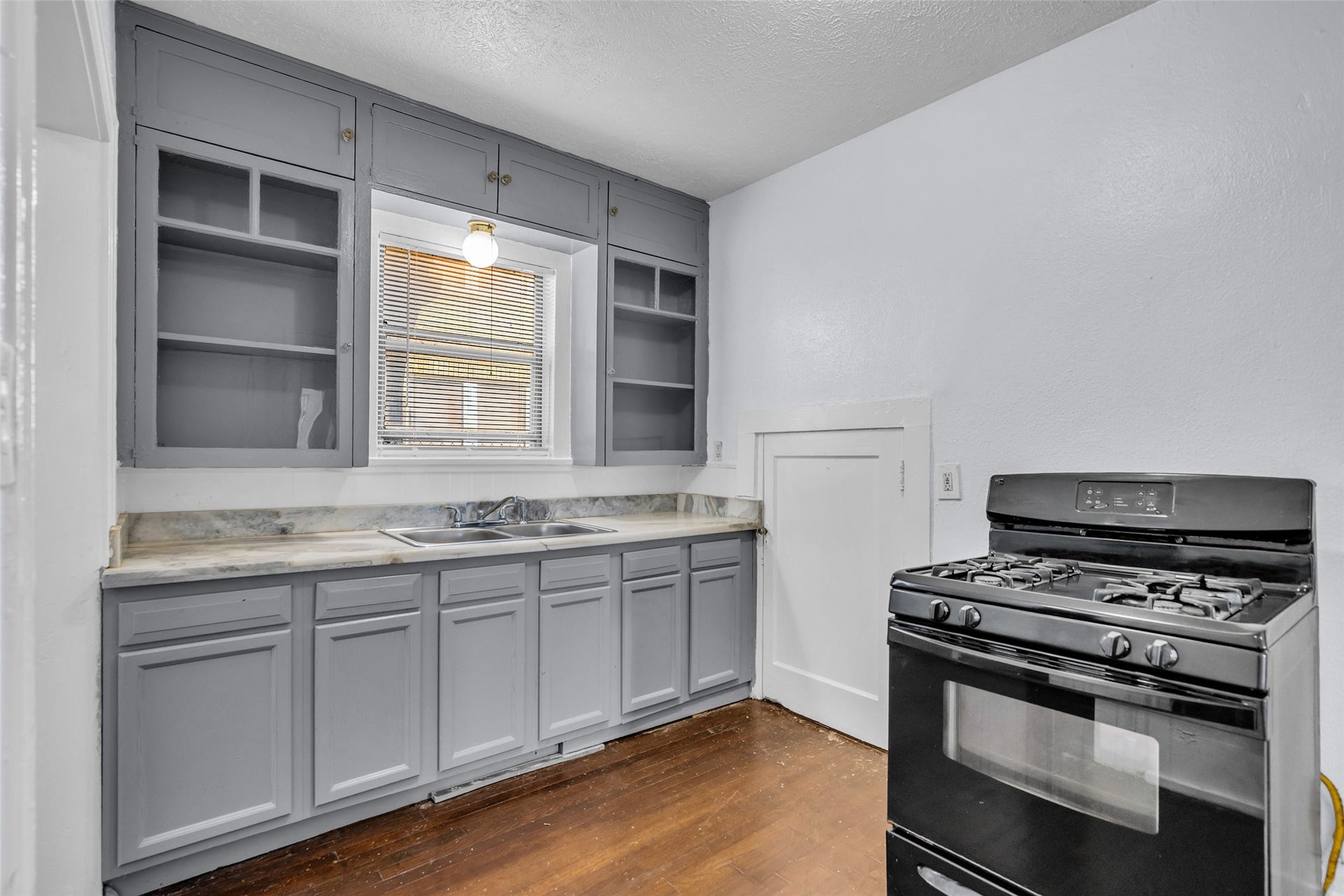 A window above the sink brings natural light into the kitchen, brightening the workspace and adding to its comfortable, functional layout.