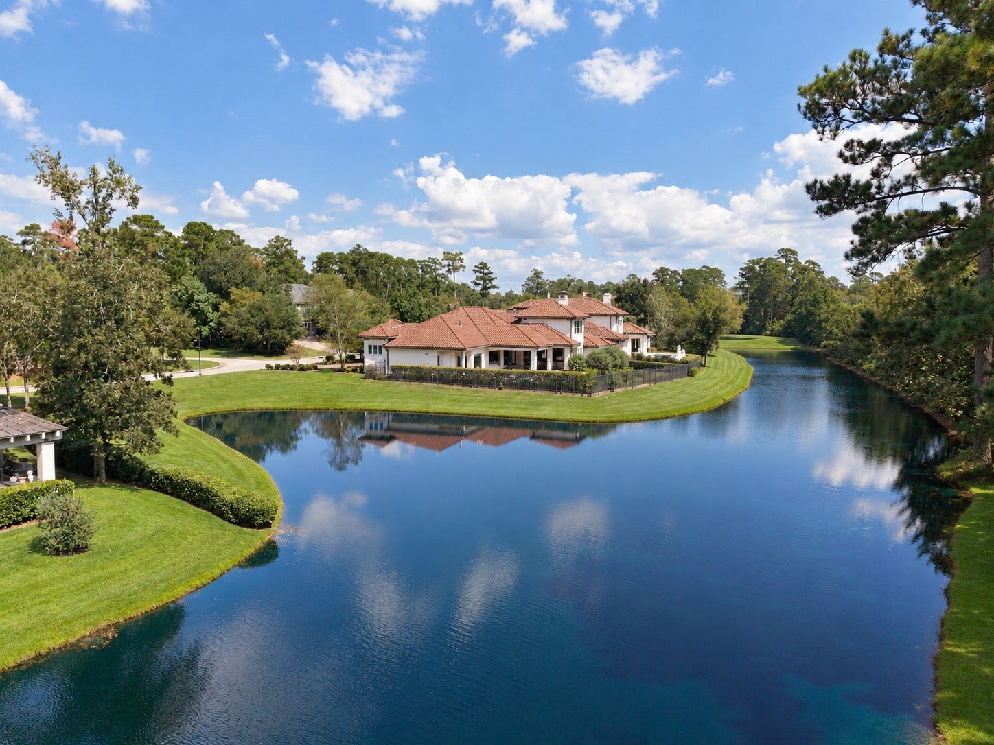 46 Lamerie Way, The Woodlands, TX 77382 Spectacular aerial view showcasing the estate's unique peninsula setting, with sparkling water on both sides and breathtaking views in every direction
