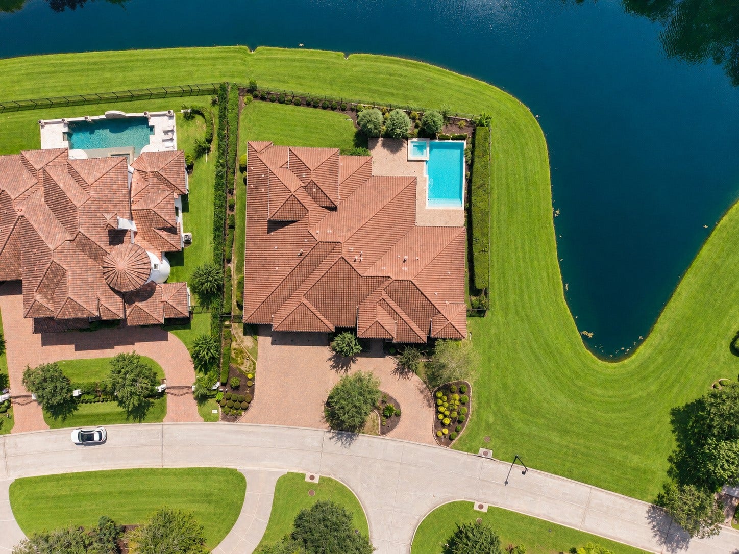 46 Lamerie Way, The Woodlands, TX 77382 overhead view showcasing the estate's expansive footprint, resort-style pool, and exceptional waterfront setting surrounded by lush green space.