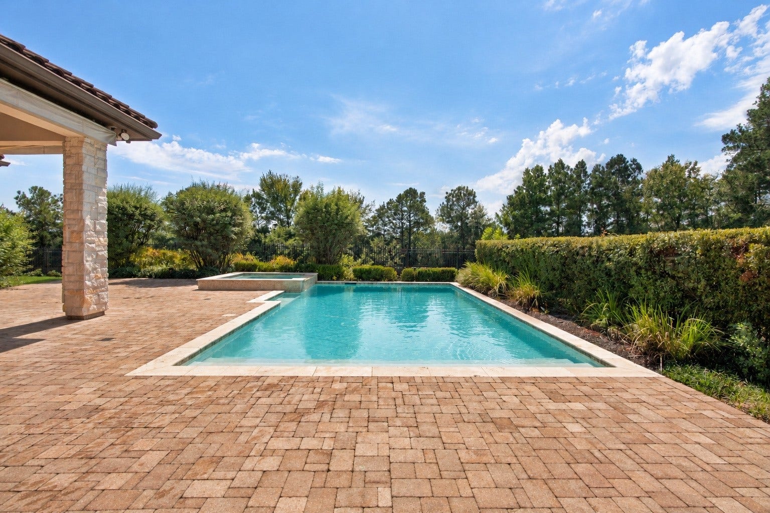 46 Lamerie Way, The Woodlands, TX 77382 Sparkling pool and spa surrounded by an expansive paver patio, lush landscaping, and beautiful wooded viewsan inviting backyard retreat!