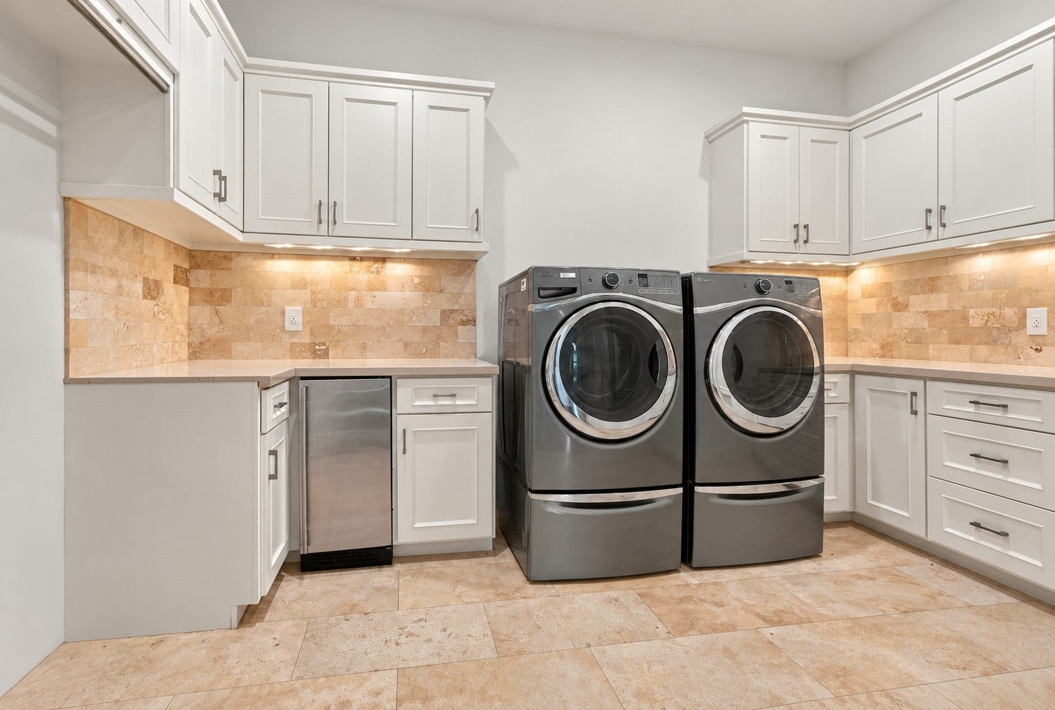 46 Lamerie Way, The Woodlands, TX 77382 Spacious utility room featuring abundant custom cabinetry, generous counter space, and full-size washer and dryer, combining luxury with everyday functionality.