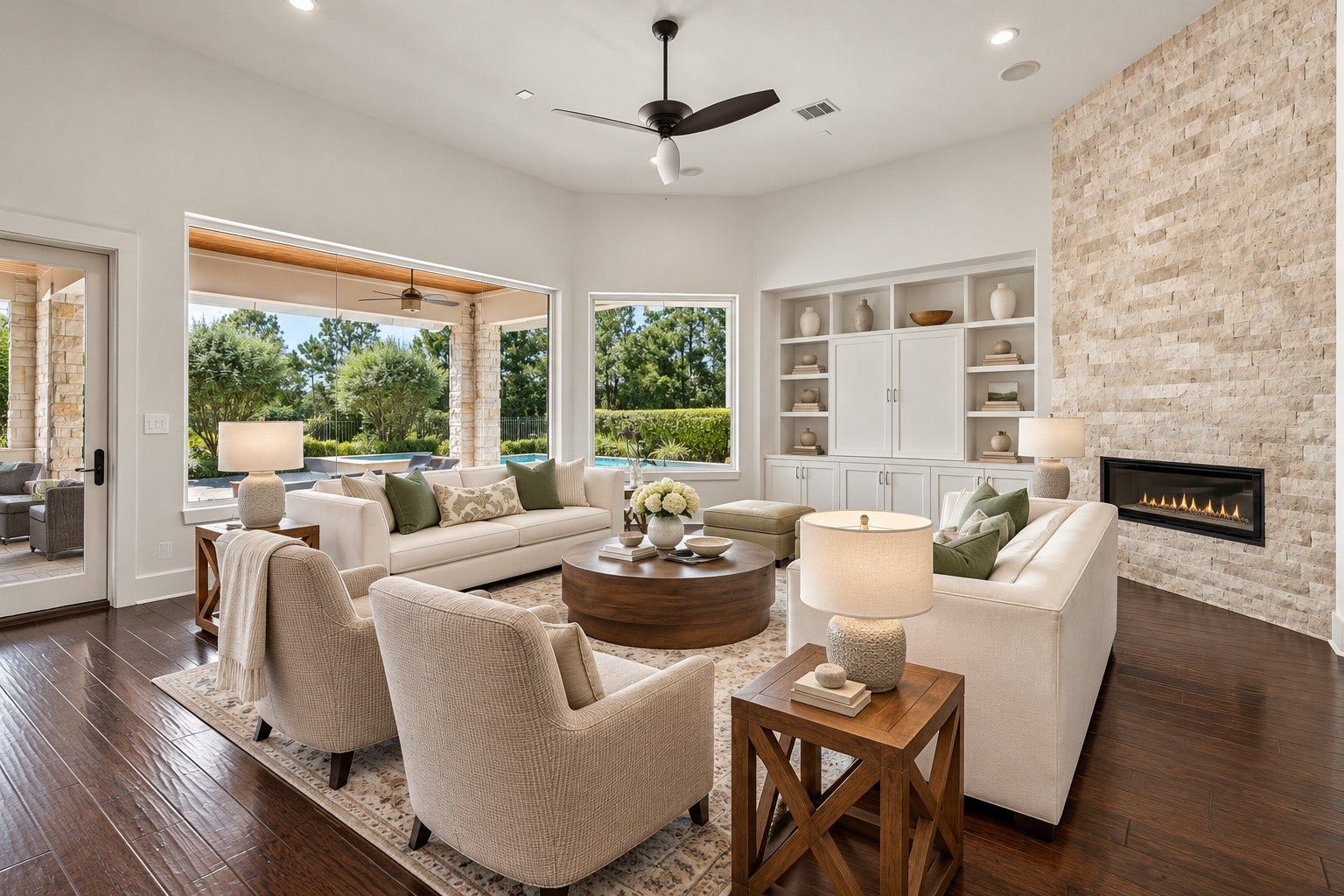 46 Lamerie Way, The Woodlands, TX 77382 Picturesque living room featuring a stunning stone fireplace, elegant finishes, and expansive windows overlooking the resort-style pool and covered patio.
