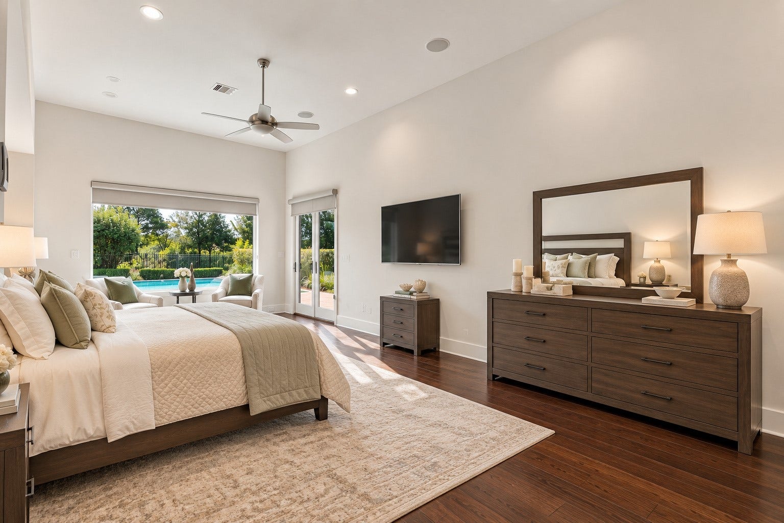 46 Lamerie Way, The Woodlands, TX 77382 Doors open directly to the backyard pool area from this luxurious primary suite, featuring soaring ceilings, elegant finishes, a spacious sitting area, and beautiful views of the backyard oasis.