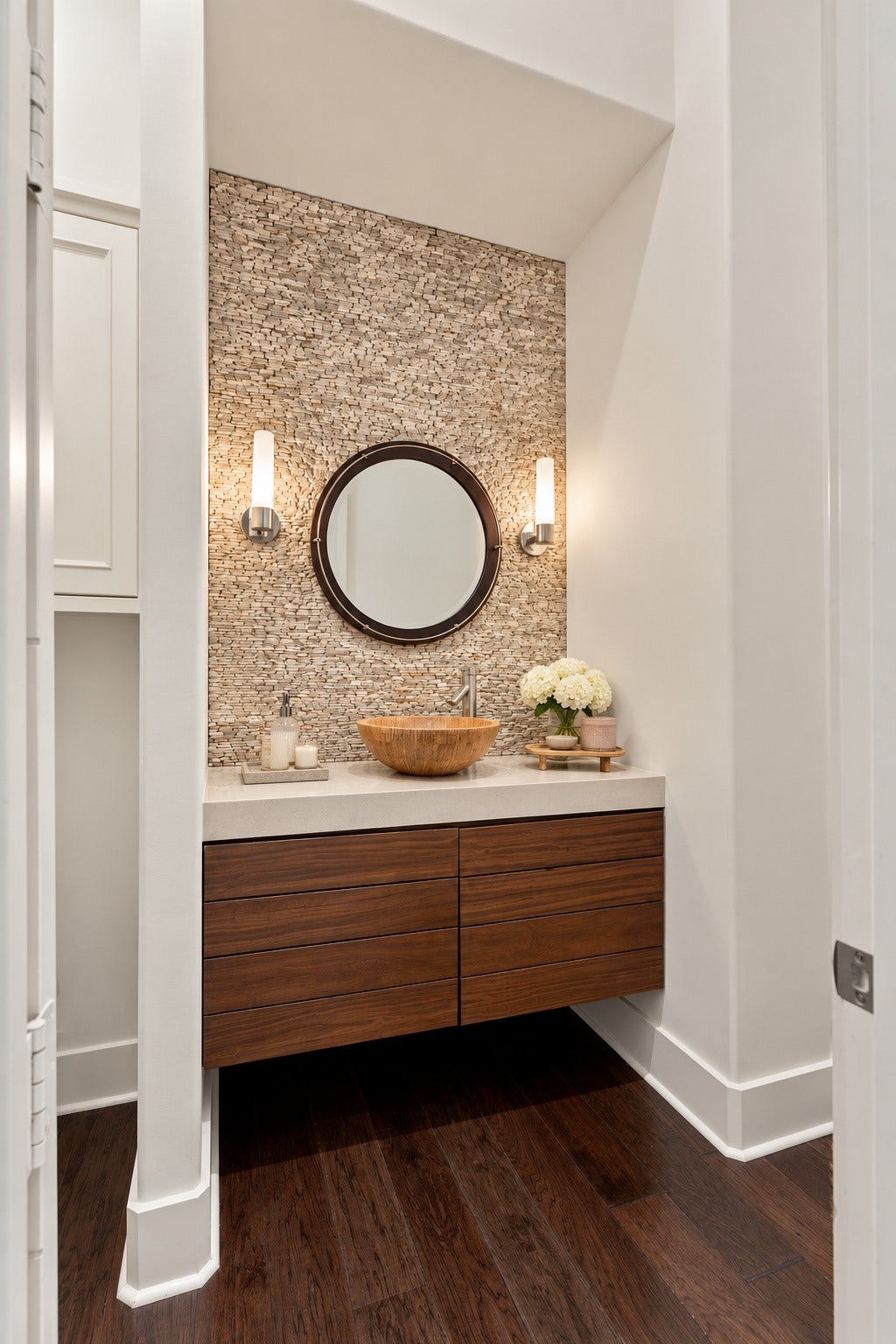 46 Lamerie Way, The Woodlands, TX 77382 Elegant half bath featuring a floating wood vanity, vessel sink, designer lighting, and a beautiful textured stone accent wall.