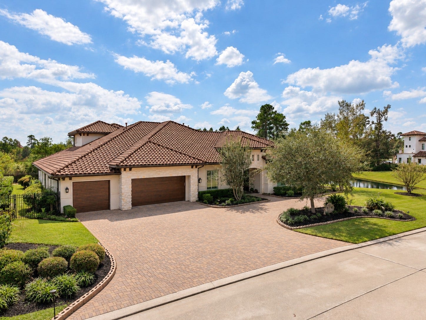 46 Lamerie Way, The Woodlands, TX 77382 Spacious four-car garage complemented by an expansive paver driveway, offering ample parking and an impressive entrance to this luxury estate.