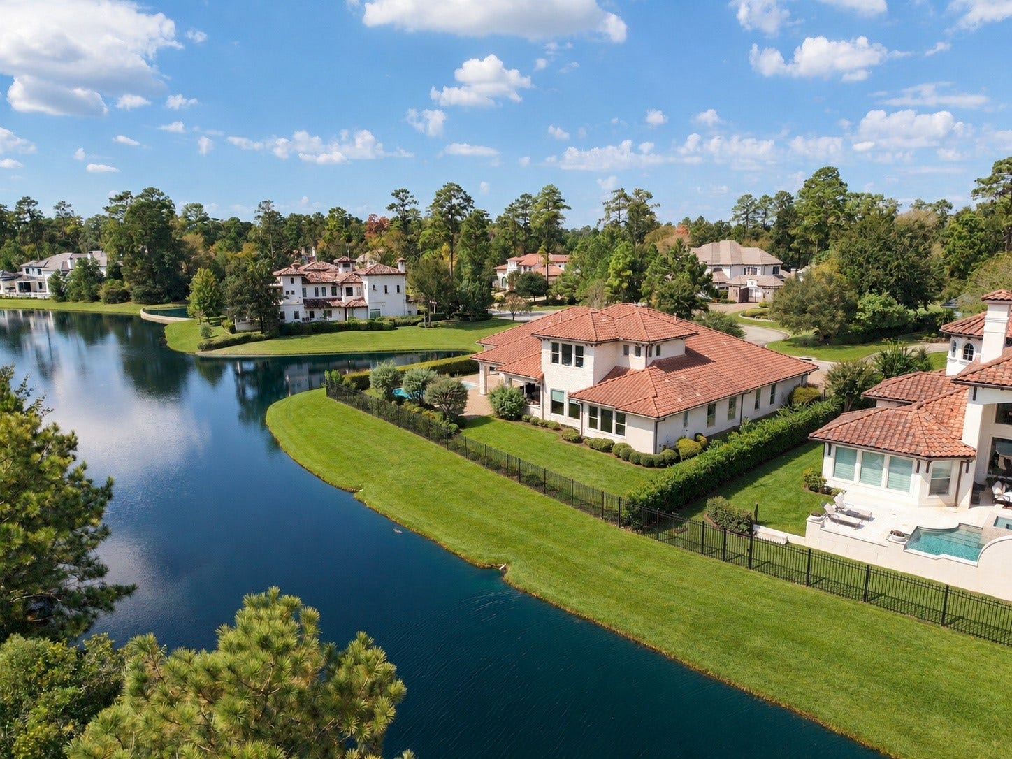 46 Lamerie Way, The Woodlands, TX 77382 A stunning aerial perspective showcases the home's remarkable setting, with sweeping water views, lush green surroundings, and exceptional privacy.