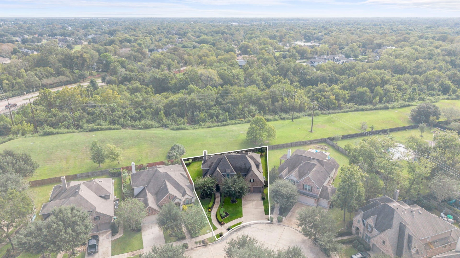 34 Stefano Way, Missouri City, TX 77459 High-altitude aerial view highlighting the property line and lot boundaries set within a quiet cul-de-sac. Shows the expansive green reserve buffer running behind the private backyard and wood fencing.