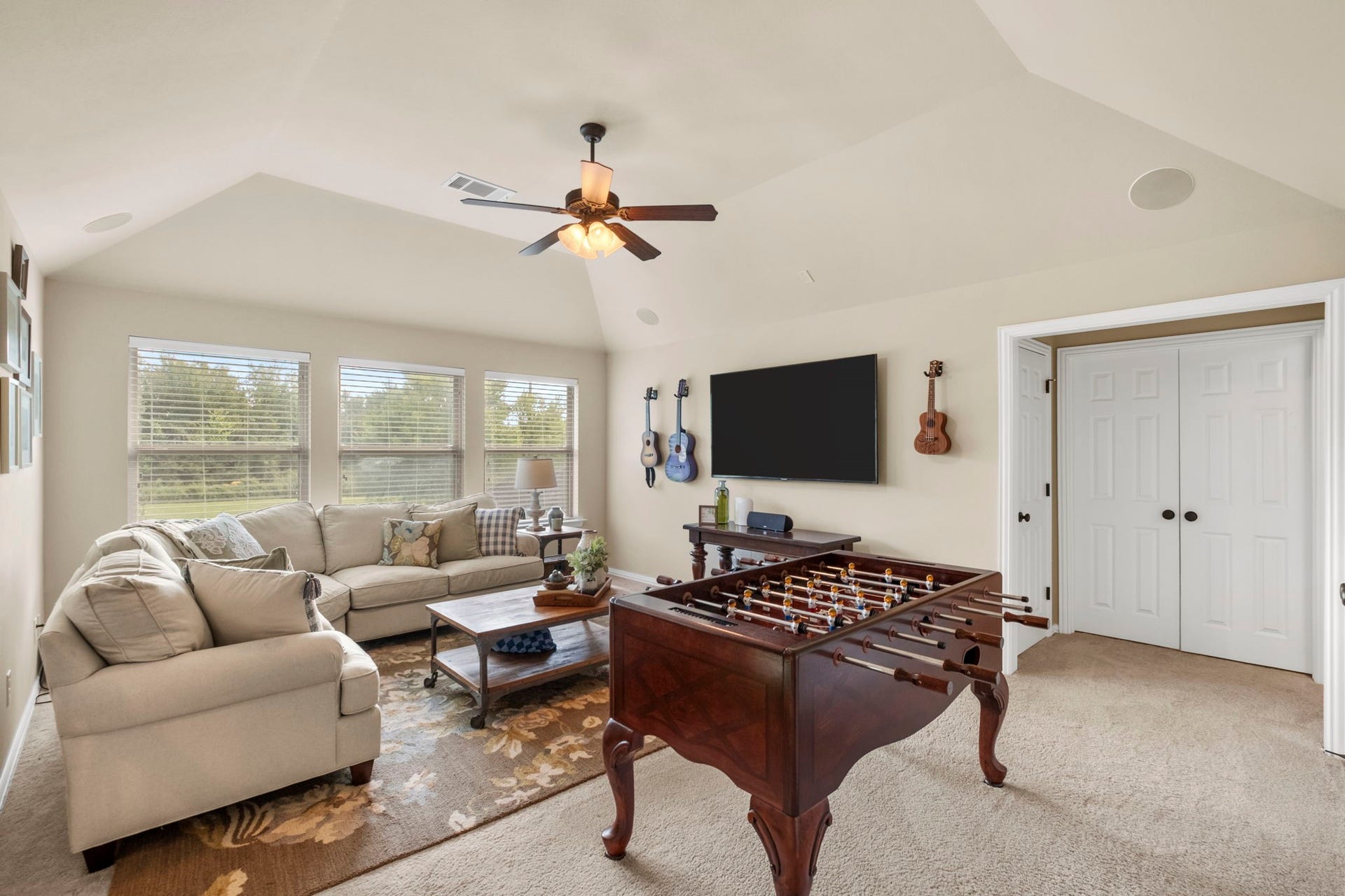 34 Stefano Way, Missouri City, TX 77459 Expansive upstairs game room or media space boasting vaulted ceilings, integrated ceiling speakers, a ceiling fan, plush carpeting, and three large double-hung windows providing elevated natural lighting. Includes a walk-in storage closet.
