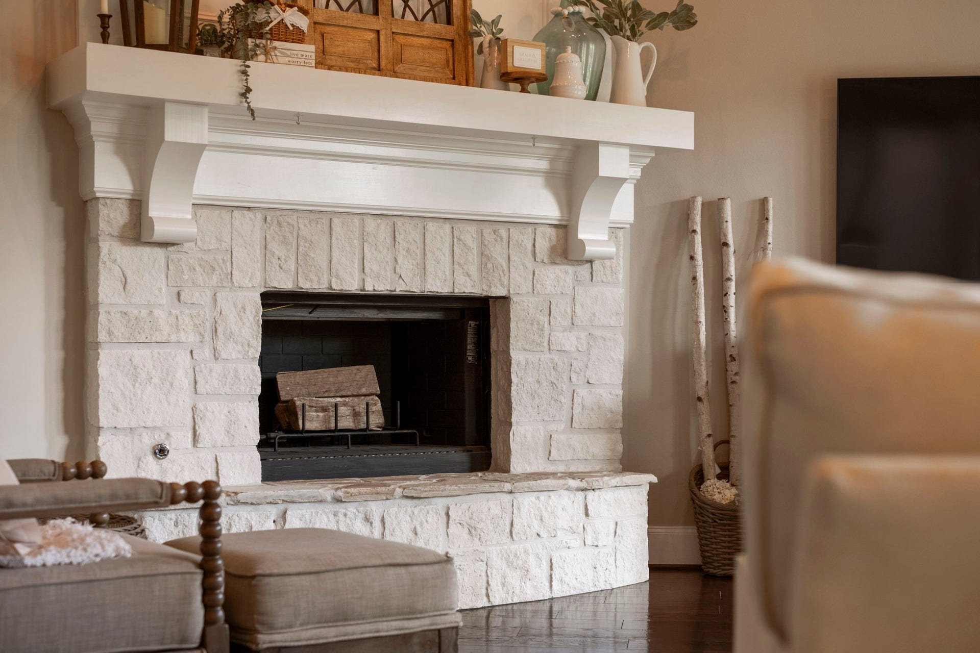 34 Stefano Way, Missouri City, TX 77459 Close-up architectural detail of the main living area fireplace, showcasing light-colored natural cut-stone masonry, a raised hearth stone bench, and a substantial painted wood mantle with decorative support corbels.