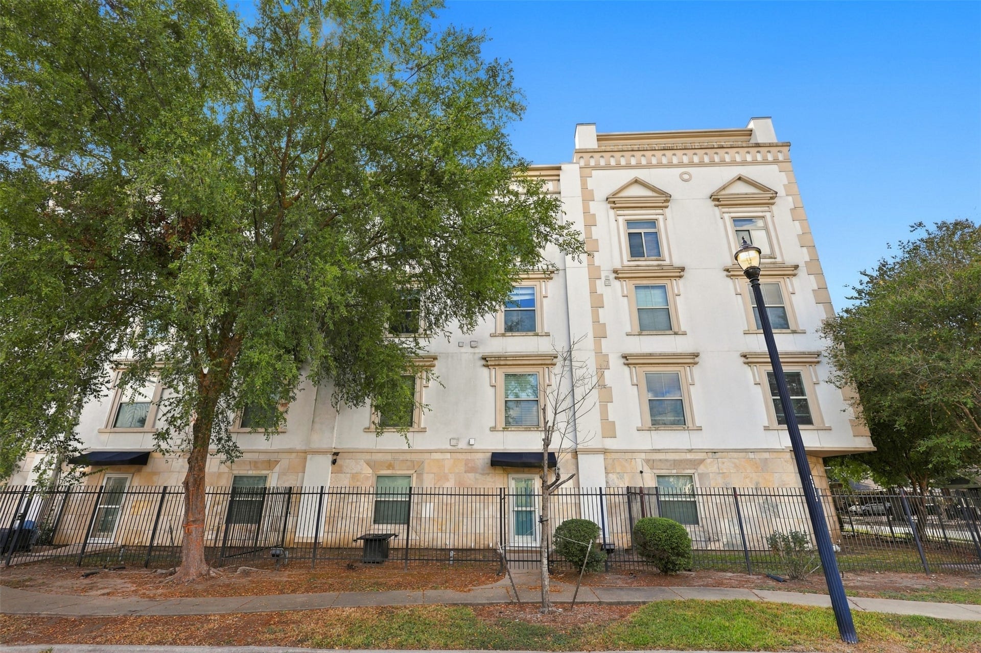3501 Chenevert Street, #3, Houston, TX 77004 Elegant four-story building with classic architectural details, complemented by lush greenery and a secure fenced perimeter.