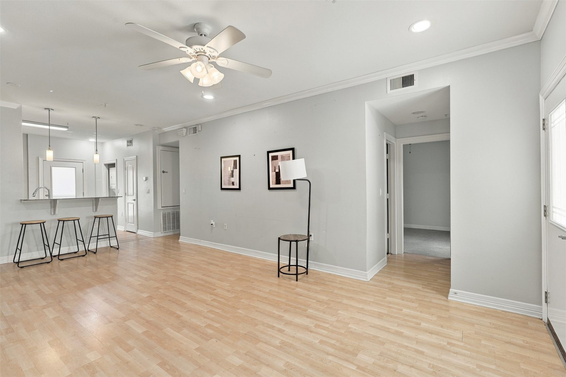 3501 Chenevert Street, #3, Houston, TX 77004 Spacious open-concept living area with light wood flooring, featuring a breakfast bar with modern pendant lighting and comfortable seating, ideal for entertaining.