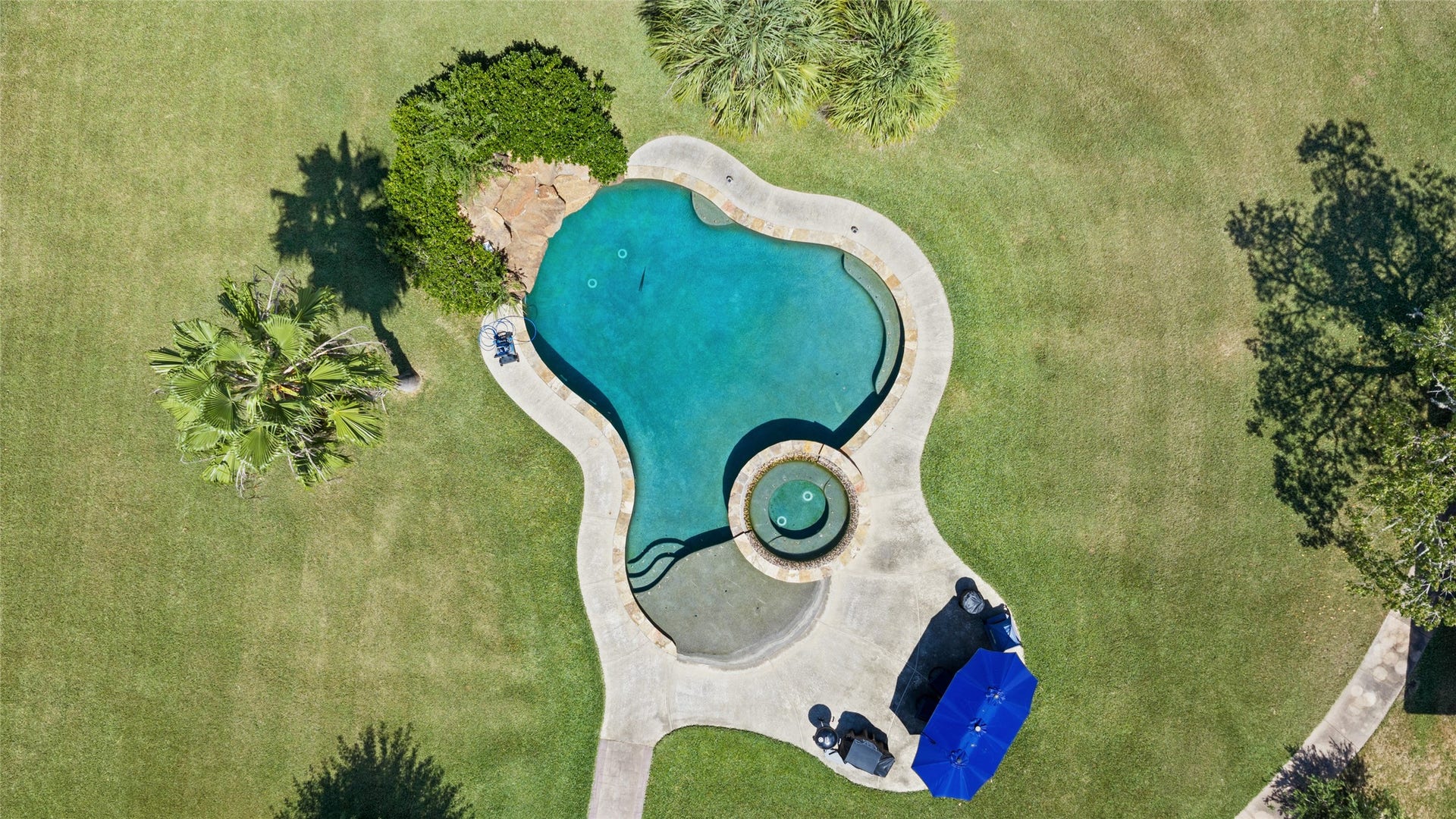 111 County Road 932, Alvin, TX 77511 This aerial view shows off one of the best features of the property, the beach entry pool with connected hot tub.