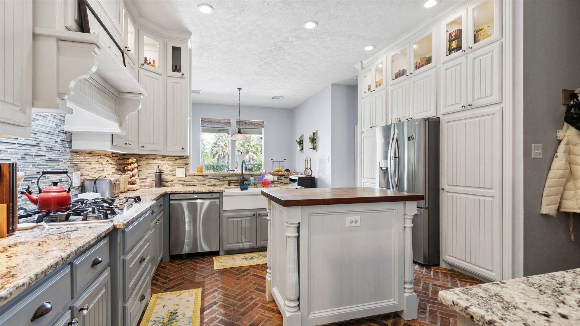 111 County Road 932, Alvin, TX 77511 A butcher block island anchors the kitchen, while the brick flooring adds a unique touch of character.