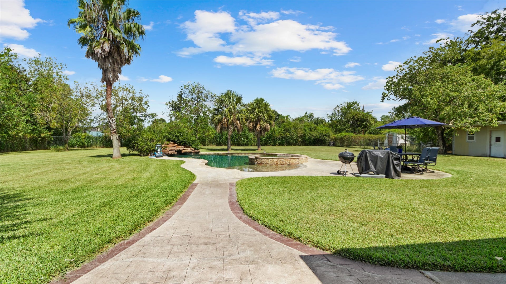 111 County Road 932, Alvin, TX 77511 As you head toward the pool, you can really appreciate the privacy and space this backyard offers. To the very right, you can see the storage / workshop area and even a fenced off chicken coop area.