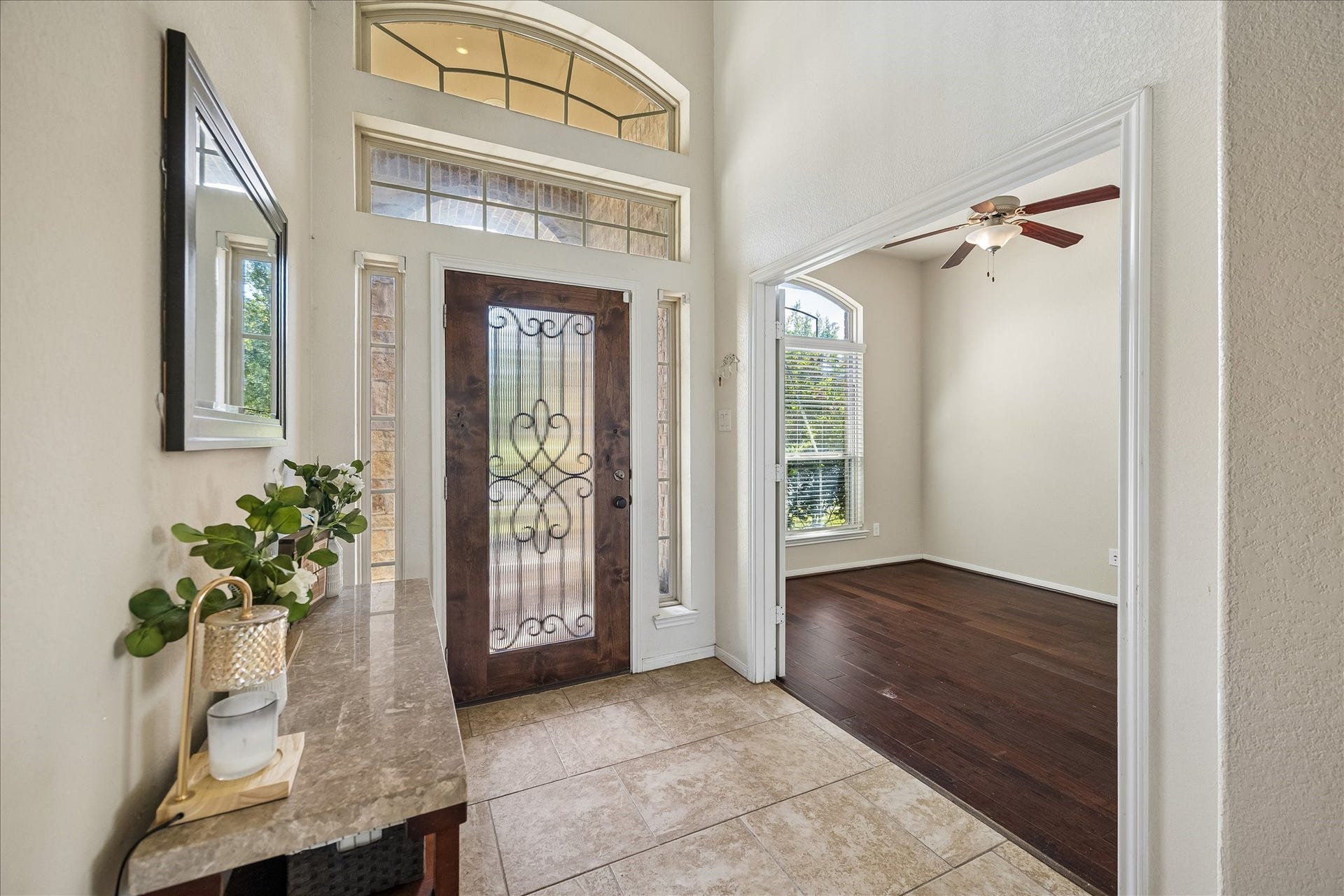 10018 Mahaffey Road, Tomball, TX 77375 Stunning entryway featuring soaring ceilings, an elegant front door with decorative glass, and an abundance of natural light. Seamlessly opens to the home office.