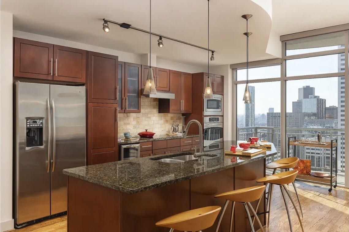 1400 McKinney Street, #2304, Houston, TX 77010 At the heart of the home, this beautifully appointed kitchen offers premium finishes, granite countertops, stainless steel appliances, a large island with bar seating and an included built-in wine chiller. The open layout and floor-to-ceiling windows seamlessly blend indoor living with spectacular downtown views.