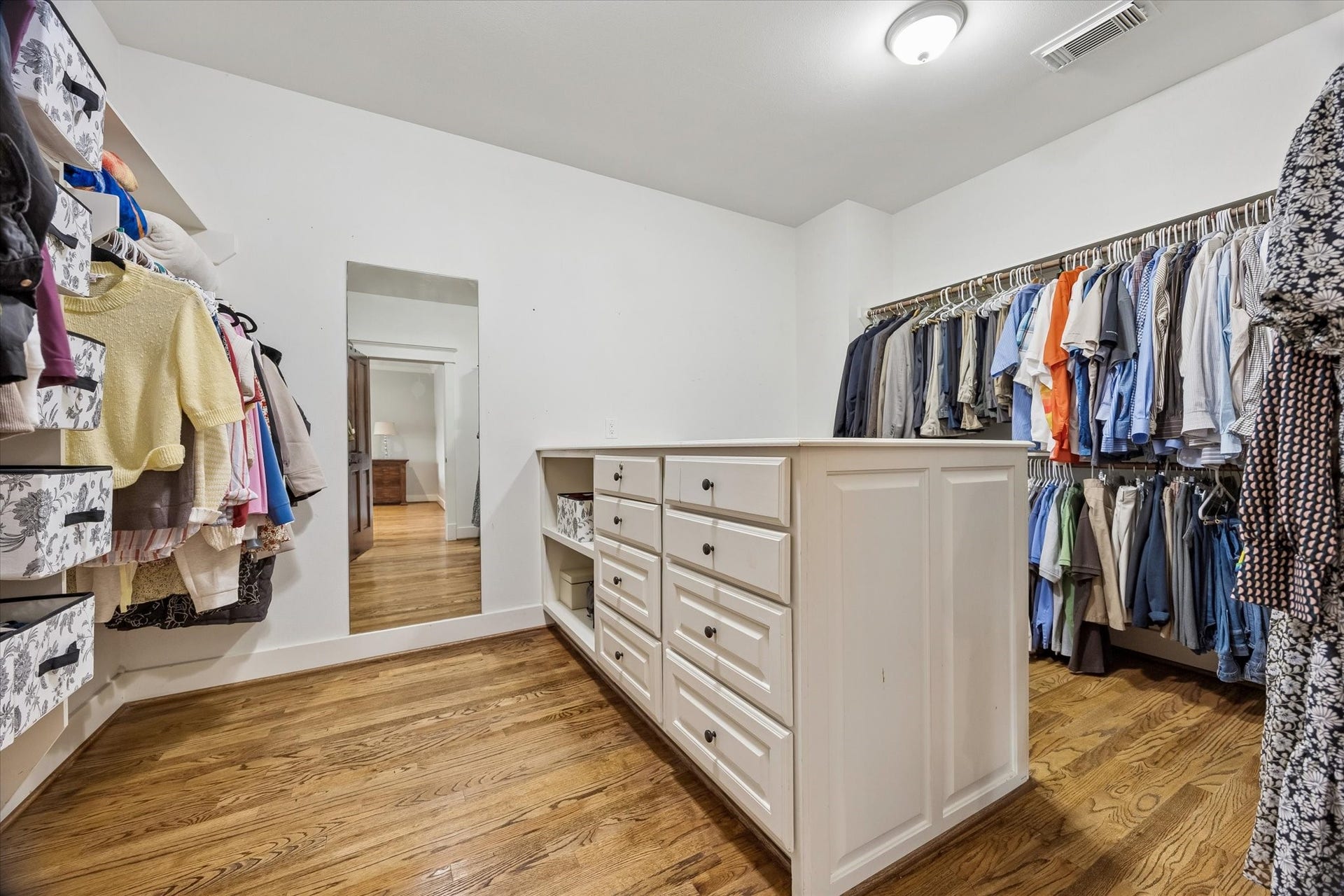 Closet goals achieved! The massive custom walk-in offers extensive hanging space, built-in drawers, shelving and a center storage island, so there is room for everything and then some.