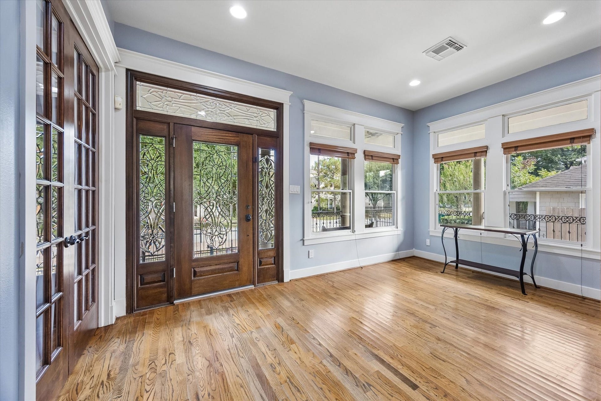 An impressive leaded glass front door with transoms sets the tone, while rich hardwood flooring, a soothing palette and beautiful natural light make the front living area feel warm, polished and easy to live in. From the moment you step inside, this home feels warm, inviting, and beautifully designed for everyday living.