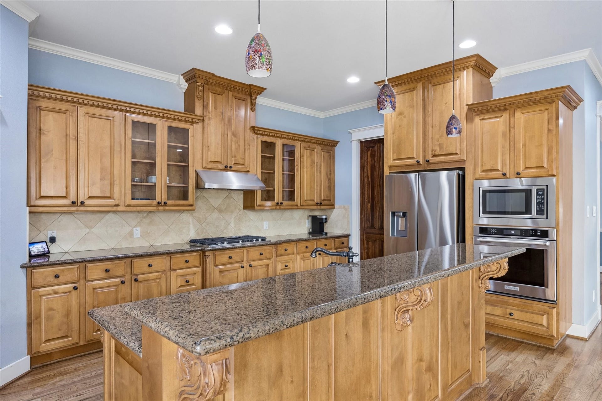 Custom warm wood cabinetry and serious function come together beautifully here. Jenn Air stainless appliances, sleek granite countertops and TWO pantries give you the storage and workspace to keep everything organized, while the easy connection to the dining and living areas makes this kitchen ready for everything from quick weeknight dinners to full scale entertaining.