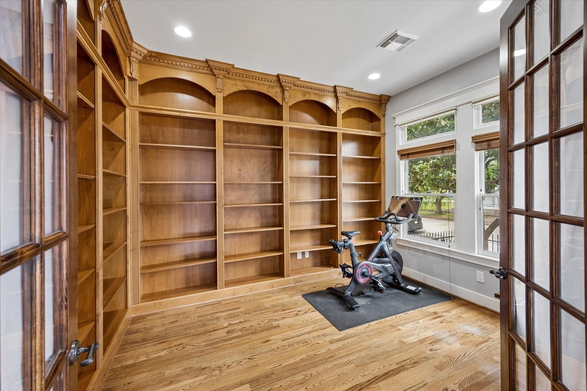 Youre going to love the morning commute when the office is right down the hall. With wood flooring, tall front facing windows and two walls of floor to ceiling wood shelving, this flexible study works beautifully as a home office, library or quiet sitting room.