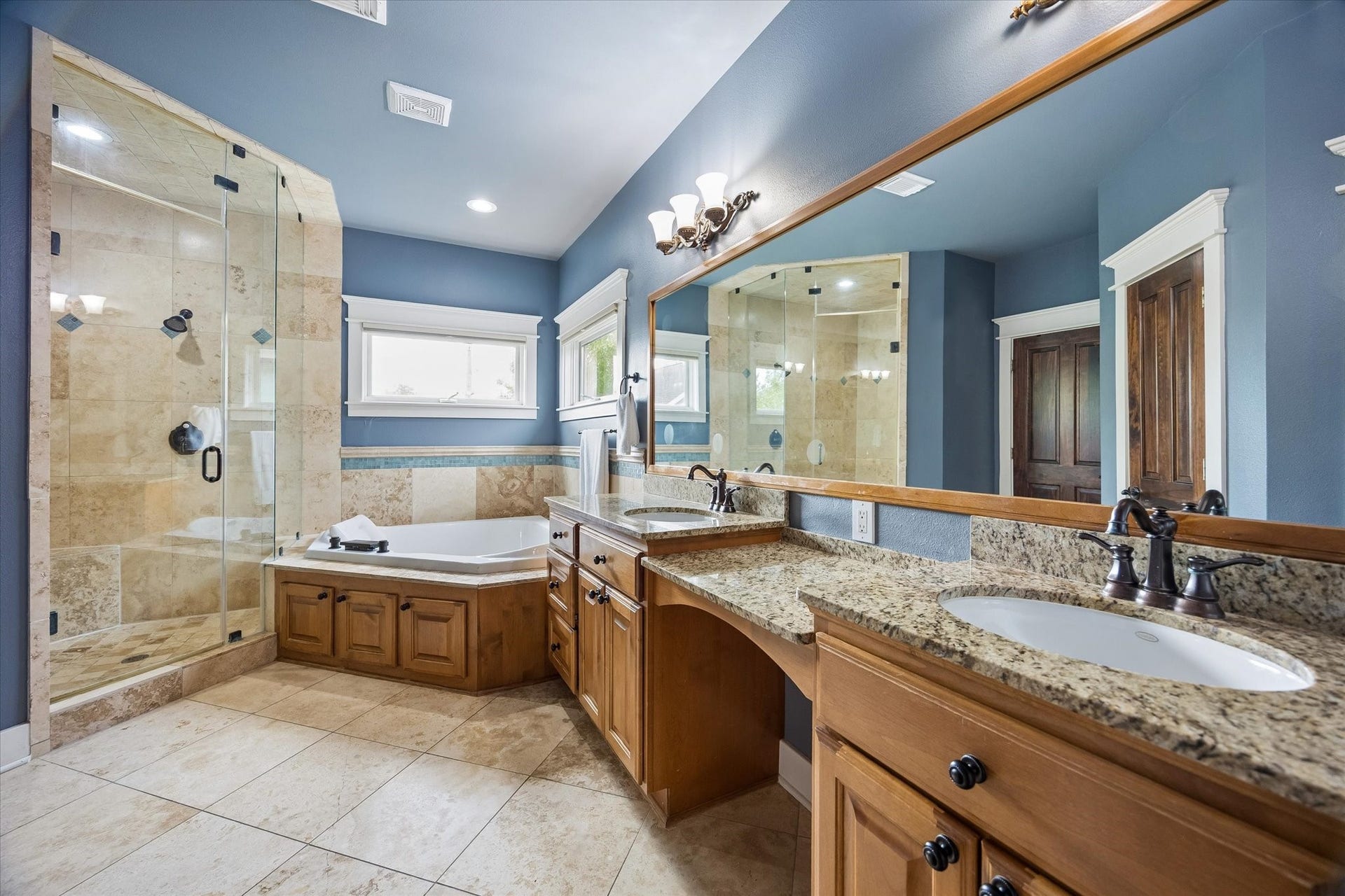 The primary bathroom brings a little everyday luxury into the routine. Dual sinks, granite counters, a deep jetted tub and a large glass enclosed shower create a spa-like space that makes mornings easier and evenings more relaxing.