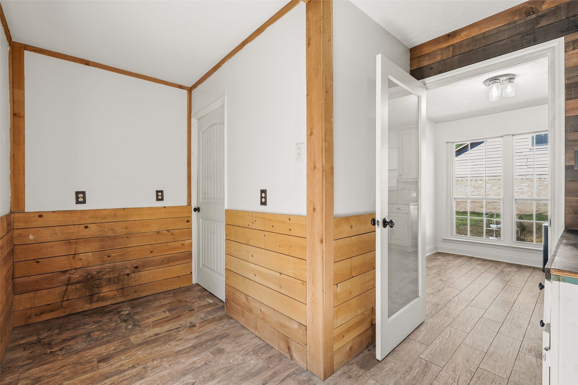 25806 Old Carriage Lane, Spring, TX 77373 Charming space featuring warm wood paneling and flooring, complemented by abundant natural light through large windows and a glass door. Perfect for a cozy, rustic feel.