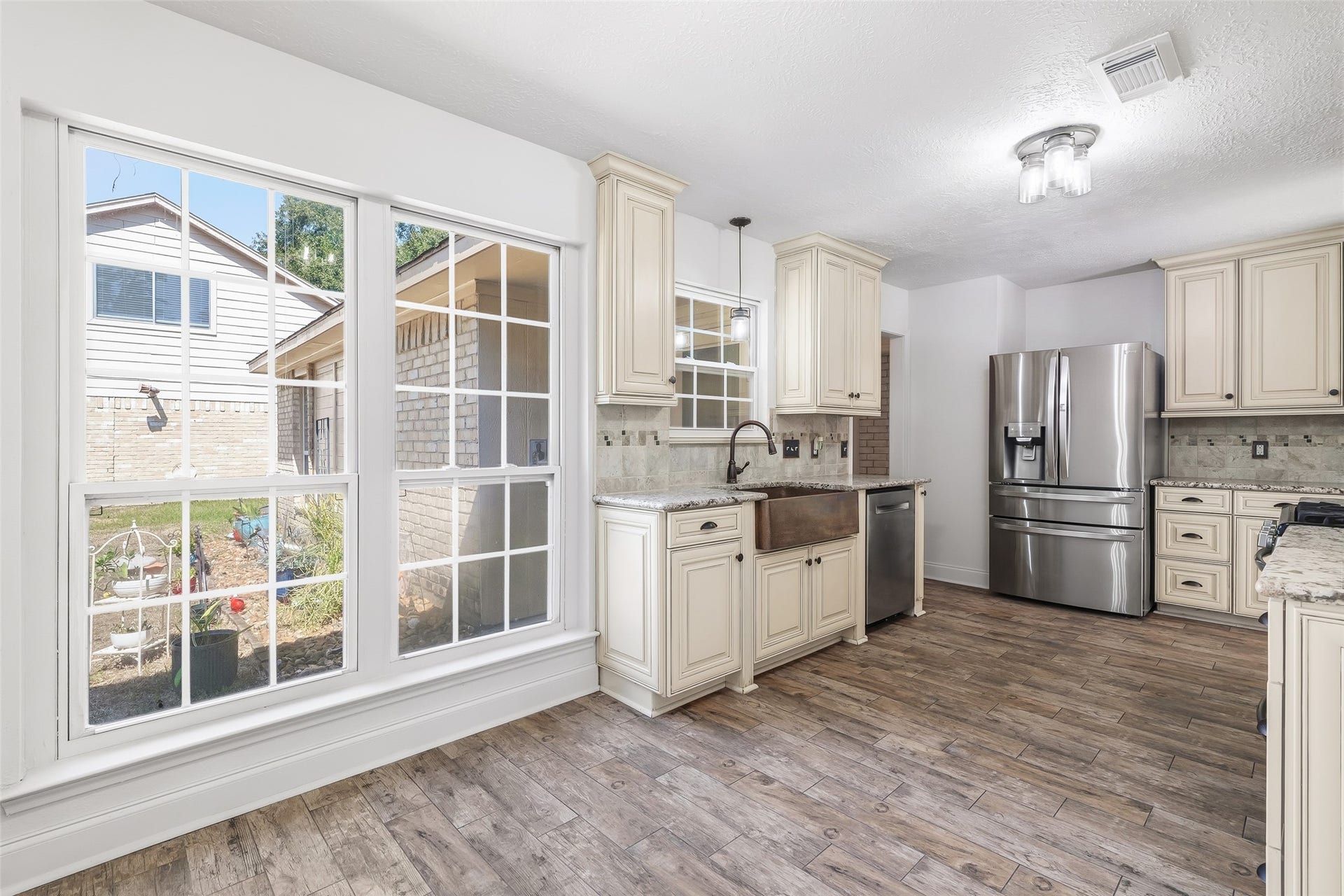 25806 Old Carriage Lane, Spring, TX 77373 Bright and inviting kitchen with large windows, elegant cabinetry and stainless steel appliances.