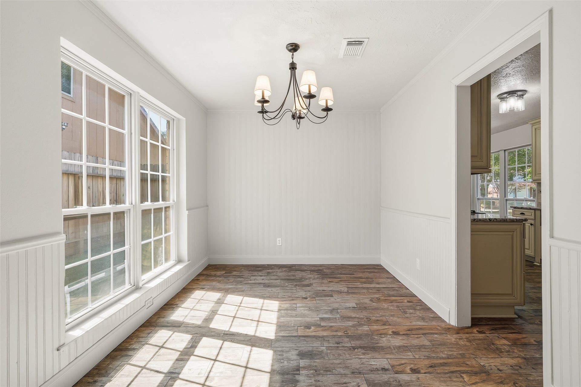 25806 Old Carriage Lane, Spring, TX 77373 Bright dining area featuring large windows and chandelier, with easy access to the adjacent kitchen.