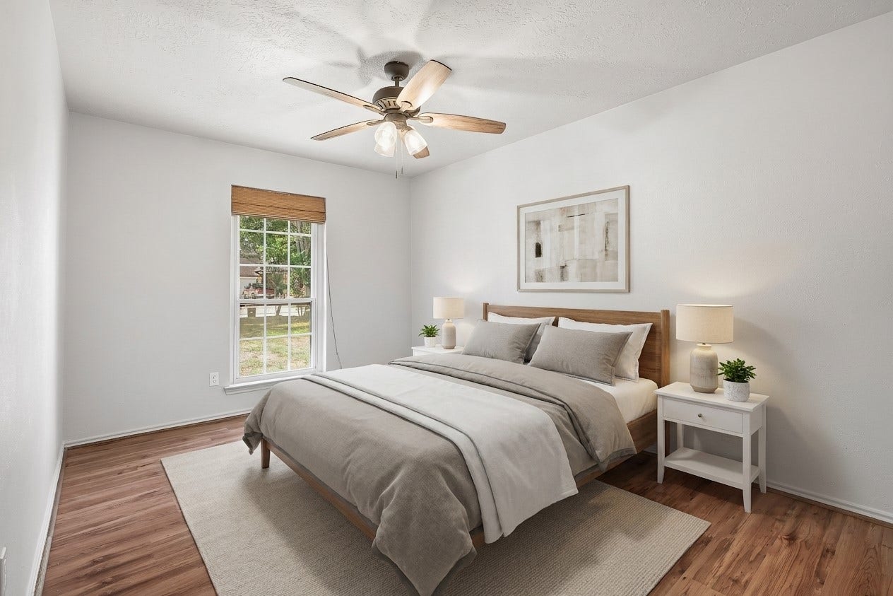 25806 Old Carriage Lane, Spring, TX 77373 Another bedroom featuring neutral tones, a ceiling fan and a large window for natural light. This image is AI enhanced.
