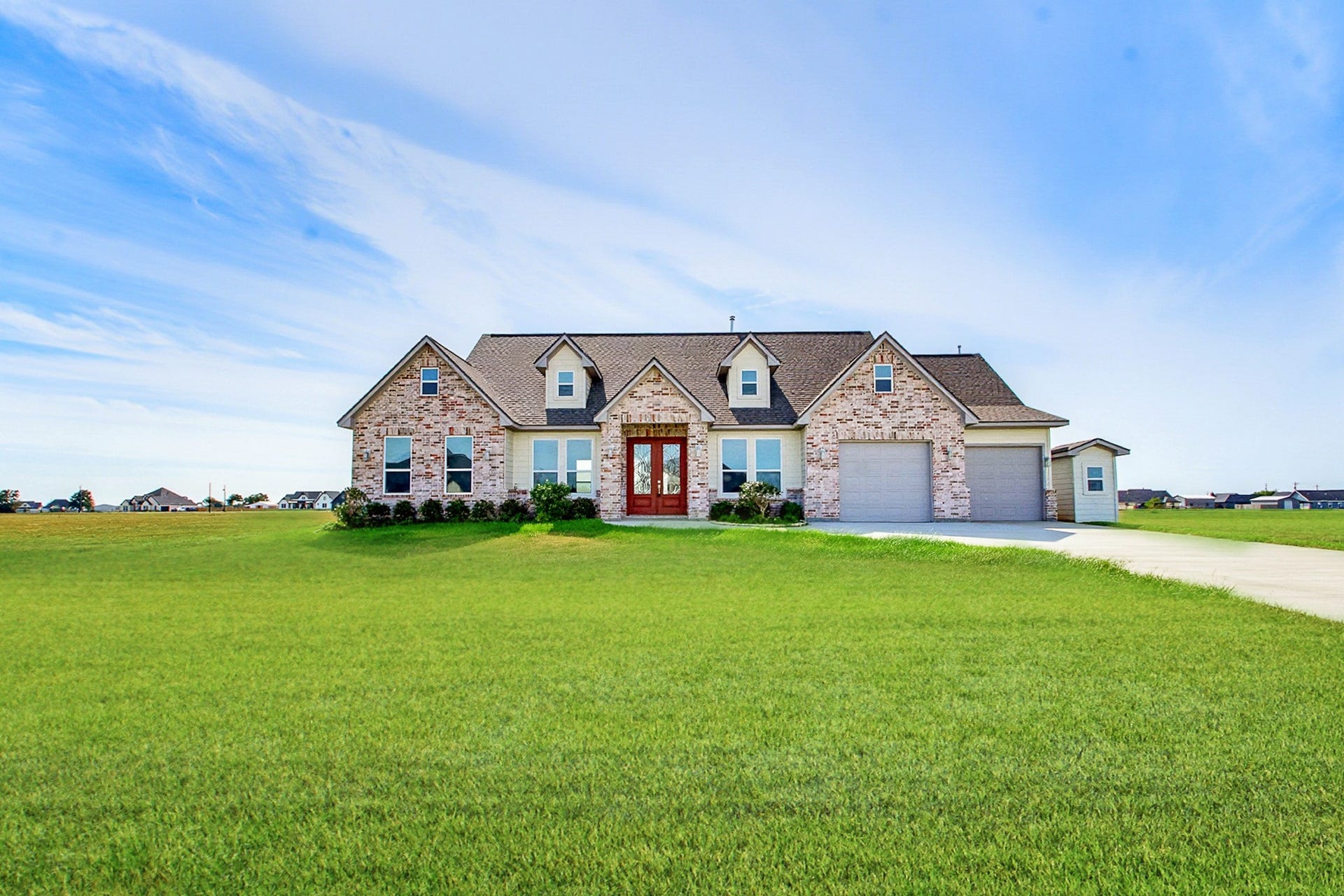 619 Longhorn Trail, Angleton, TX 77515 Charming 2389 sq.ft. brick ranch-style home with a spacious one-acre lot, inviting front entrance, and attached 549 sq.ft. two car garage, set against a picturesque sky.