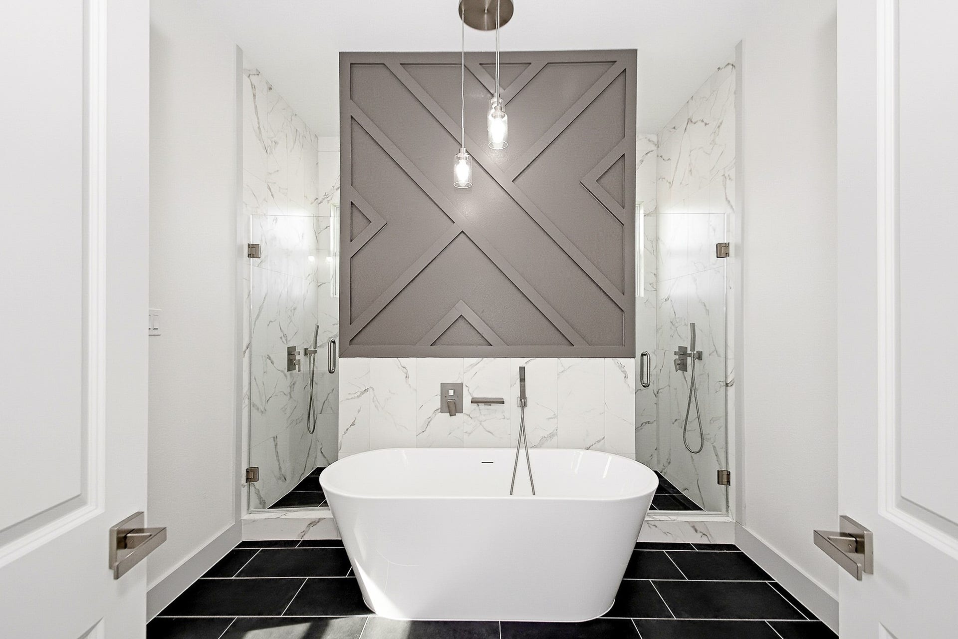 619 Longhorn Trail, Angleton, TX 77515 Luxurious 16x12 primary bathroom featuring a sleek freestanding tub, elegant walls, and dual glass showers, complemented by a striking geometric accent design.