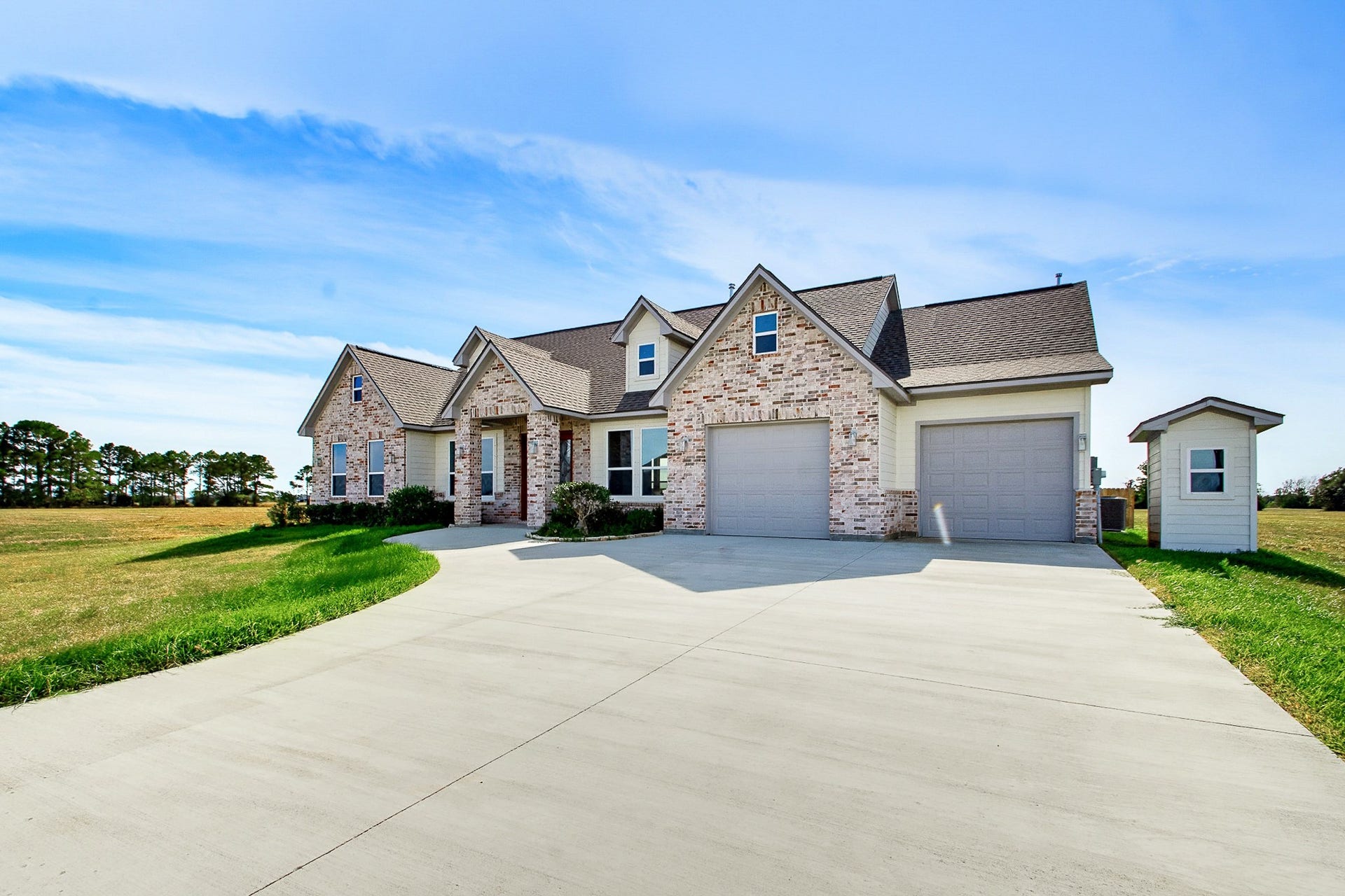 619 Longhorn Trail, Angleton, TX 77515 Charming 2389 sq.ft. brick home with a spacious 549 sq.ft. two-car garage, nestled on a sprawling one-acre lot with beautiful open fields and clear blue skies.