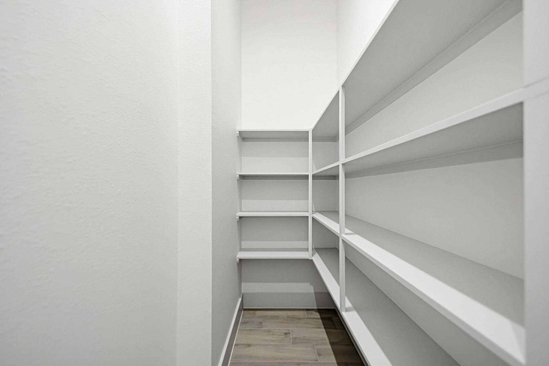 619 Longhorn Trail, Angleton, TX 77515 Spacious walk-in pantry with ample shelving for all your storage needs. The space continues to the left side for more storage space.