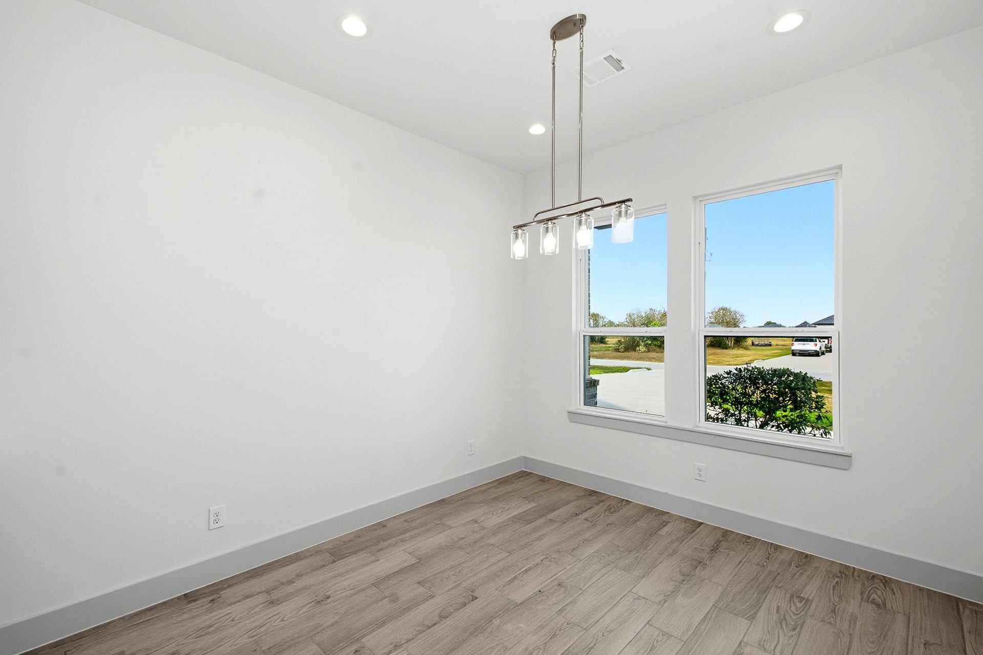 619 Longhorn Trail, Angleton, TX 77515 Bright 10.5x10.5 dining area with modern lighting, large windows, and elegant flooring, offering a cozy, inviting atmosphere.