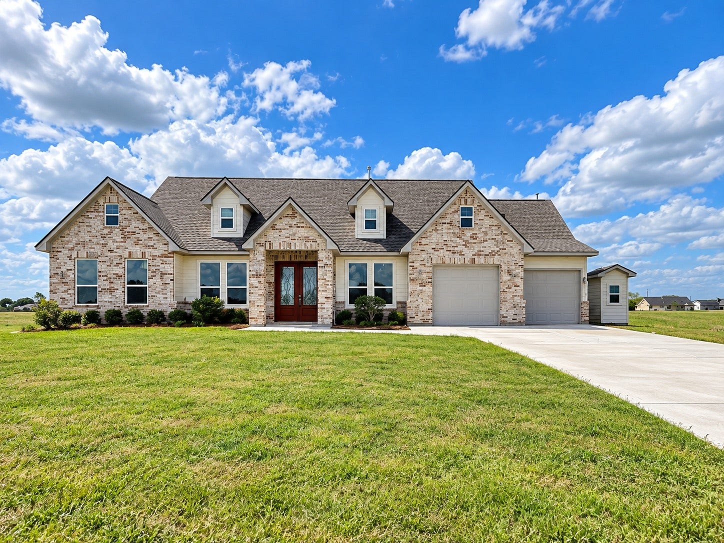 619 Longhorn Trail, Angleton, TX 77515 Charming 2389 sq.ft. brick home with a spacious double driveway, lush green lawn, and inviting double-door entry, set against a backdrop of blue skies and open fields.