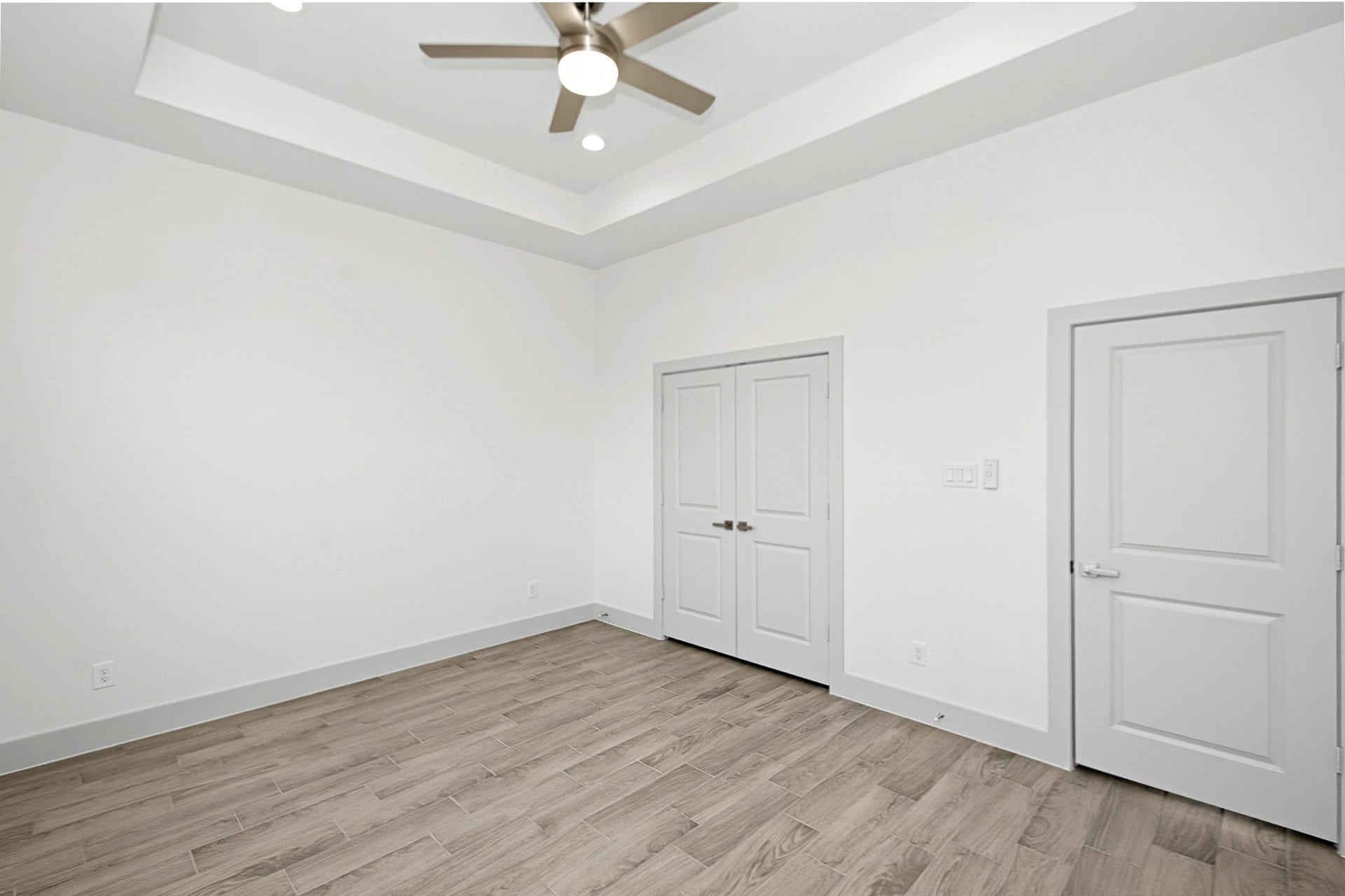 619 Longhorn Trail, Angleton, TX 77515 14.5x12 Second bedroom double door closet, modern ceiling fan and a stylish tray ceiling for added charm and sophistication.