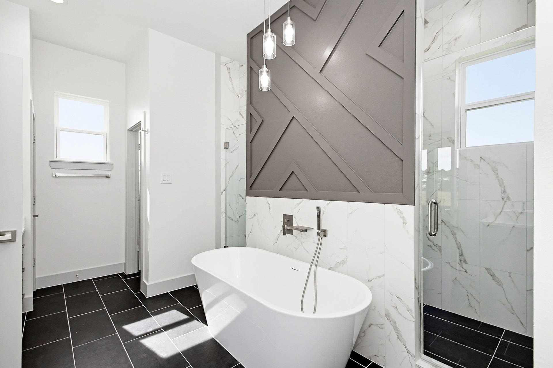 619 Longhorn Trail, Angleton, TX 77515 Luxurious 16x12 bathroom featuring a sleek freestanding tub, modern tile accents, and a spacious glass-enclosed shower for a spa-like experience.