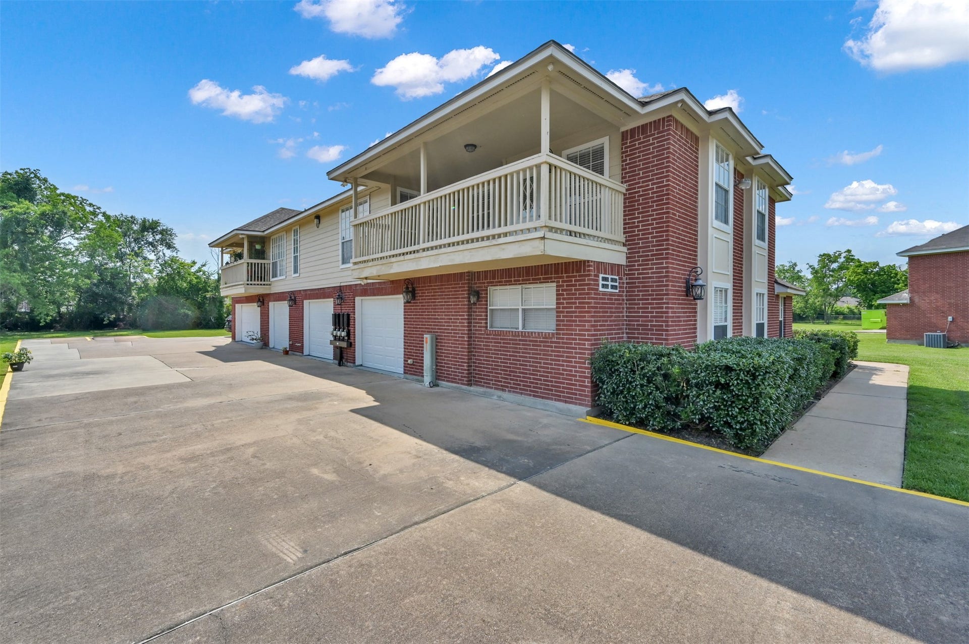 1141 Lovett Street, Tomball, TX 77375 Charming two-story brick townhouse with a spacious balcony, attached garage, and well-maintained landscaping in a peaceful neighborhood.