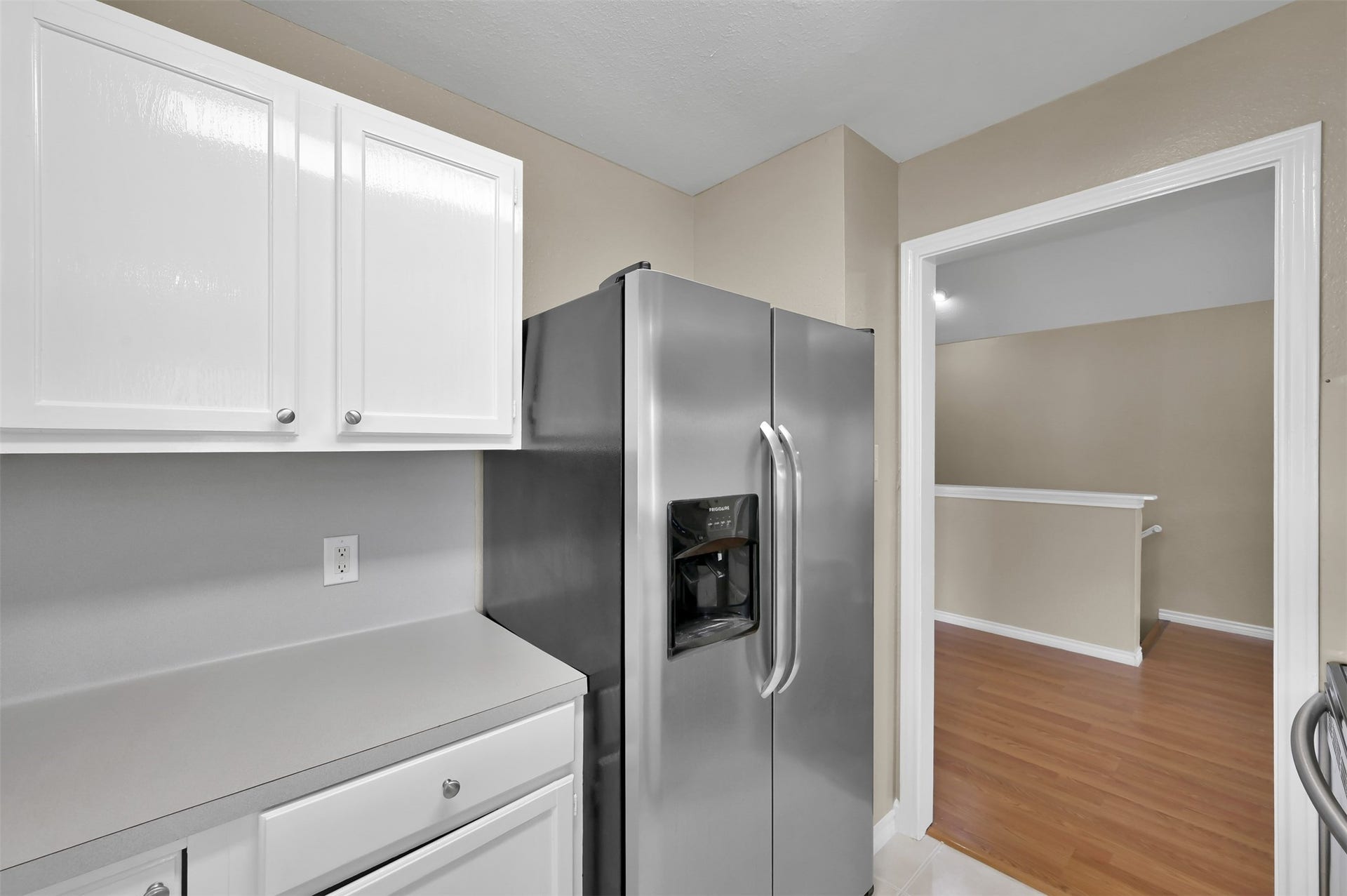 1141 Lovett Street, Tomball, TX 77375 Modern kitchen with sleek stainless steel refrigerator, crisp white cabinetry, and easy access to adjoining spaces.