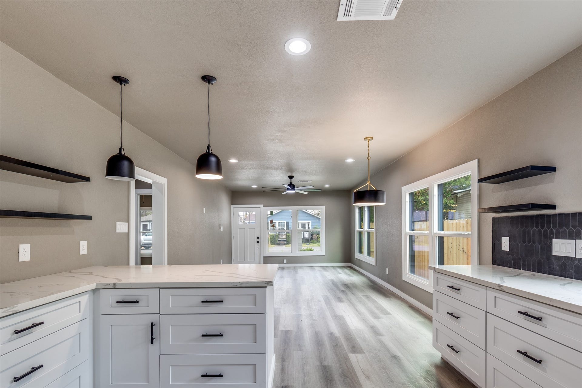 Open concept flow into the kitchen with quartz counters, black stainless steel appliances, and a peninsula that keeps everyone together.