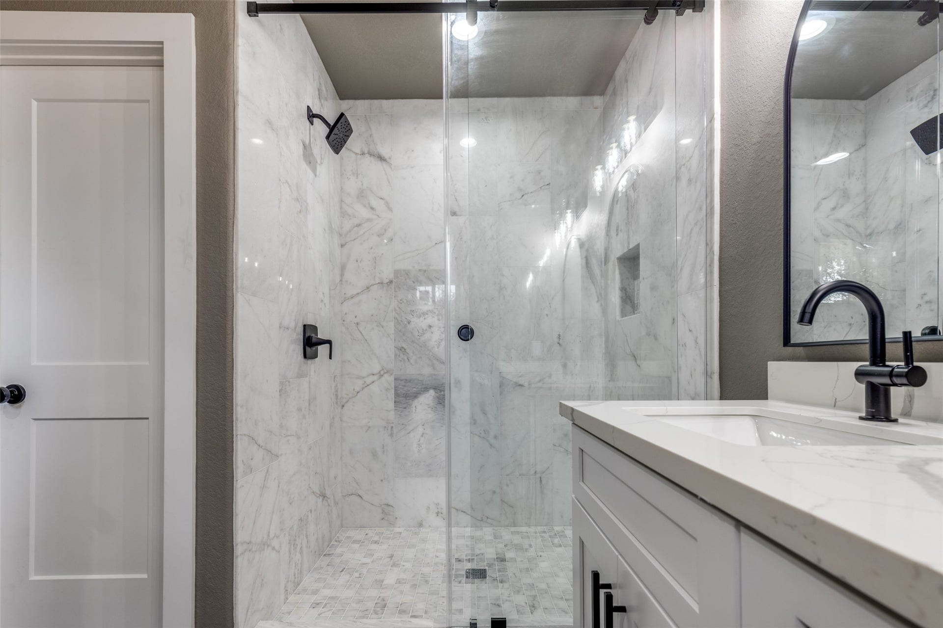 Statement shower with marble, sleek hardware, and a clean modern vanity that feels straight out of a boutique hotel.