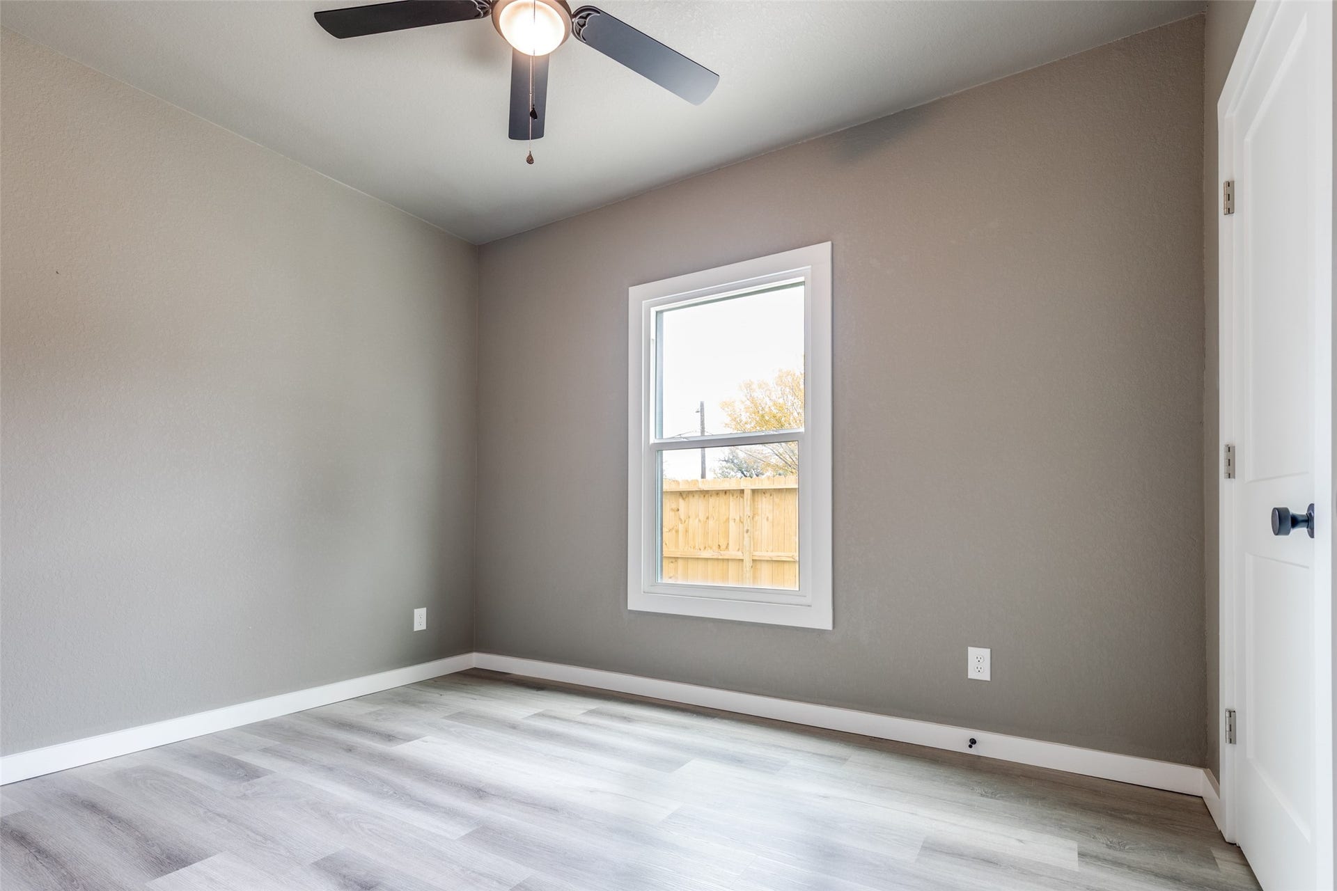 Another spacious bedroom angle showing the airy layout, updated floors, and windows that bring in natural light.