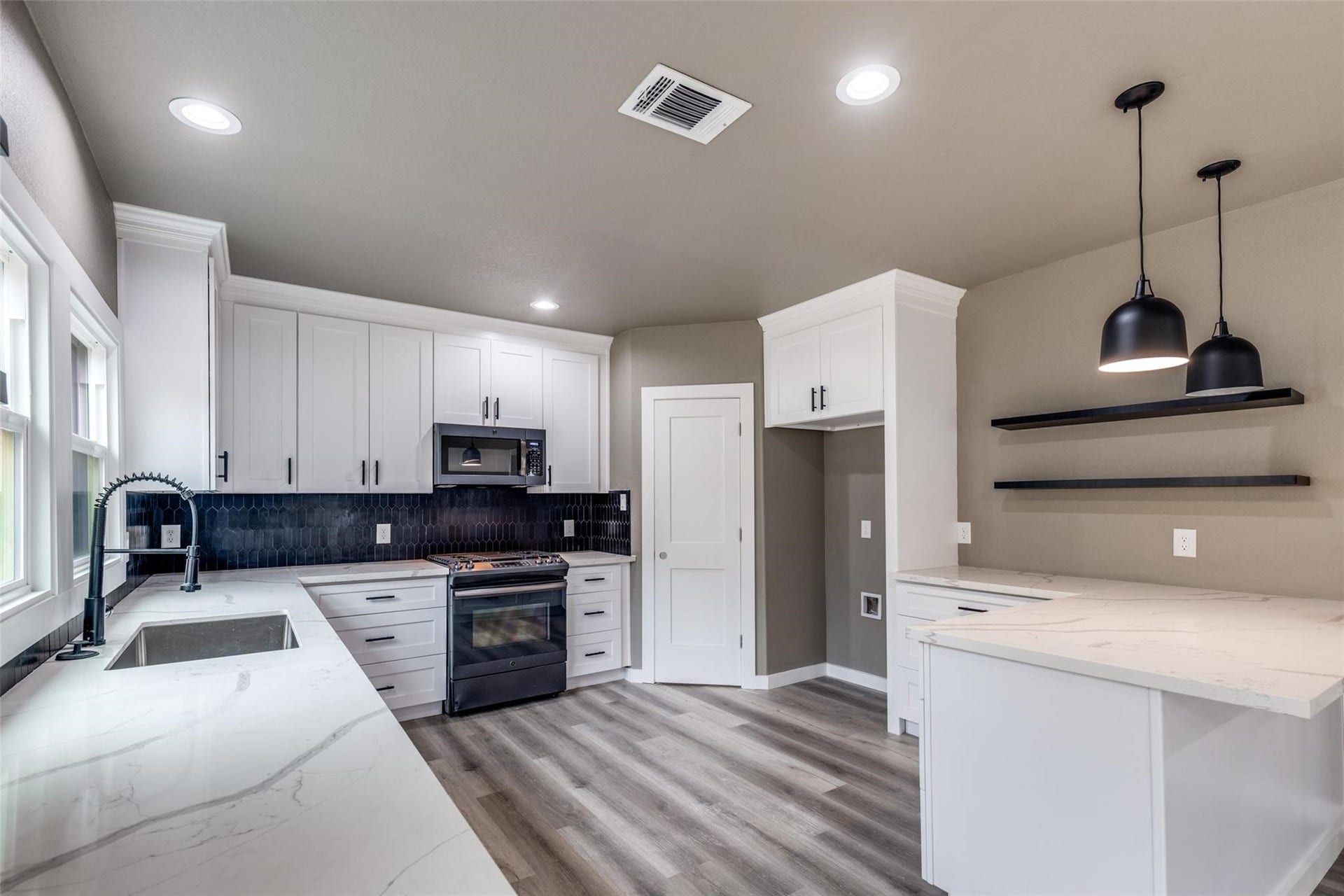 Wide angle view of the open concept kitchen and living area, light filled, move in ready, and made for entertaining.