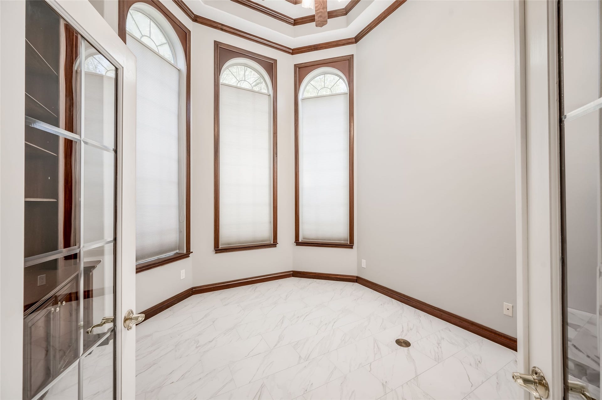 86 Pipers Walk, Sugar Land, TX 77479 French doors open to a handsome study/home office with custom built-in cabinetry and beautiful arched windows.