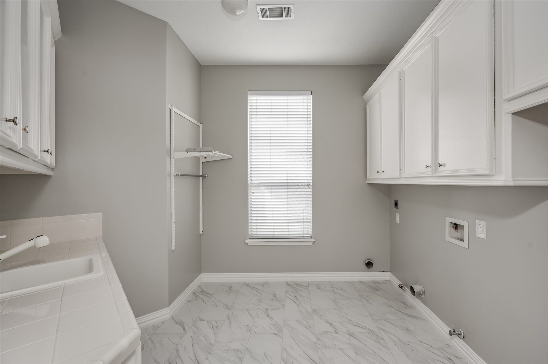 86 Pipers Walk, Sugar Land, TX 77479 1st floor laundry room features built-in storage cabinets, sink, counter space, large window, and room for a second refrigerator.